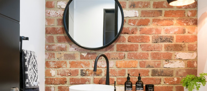 ronde mat zwarte spiegel en accessoires badkamer